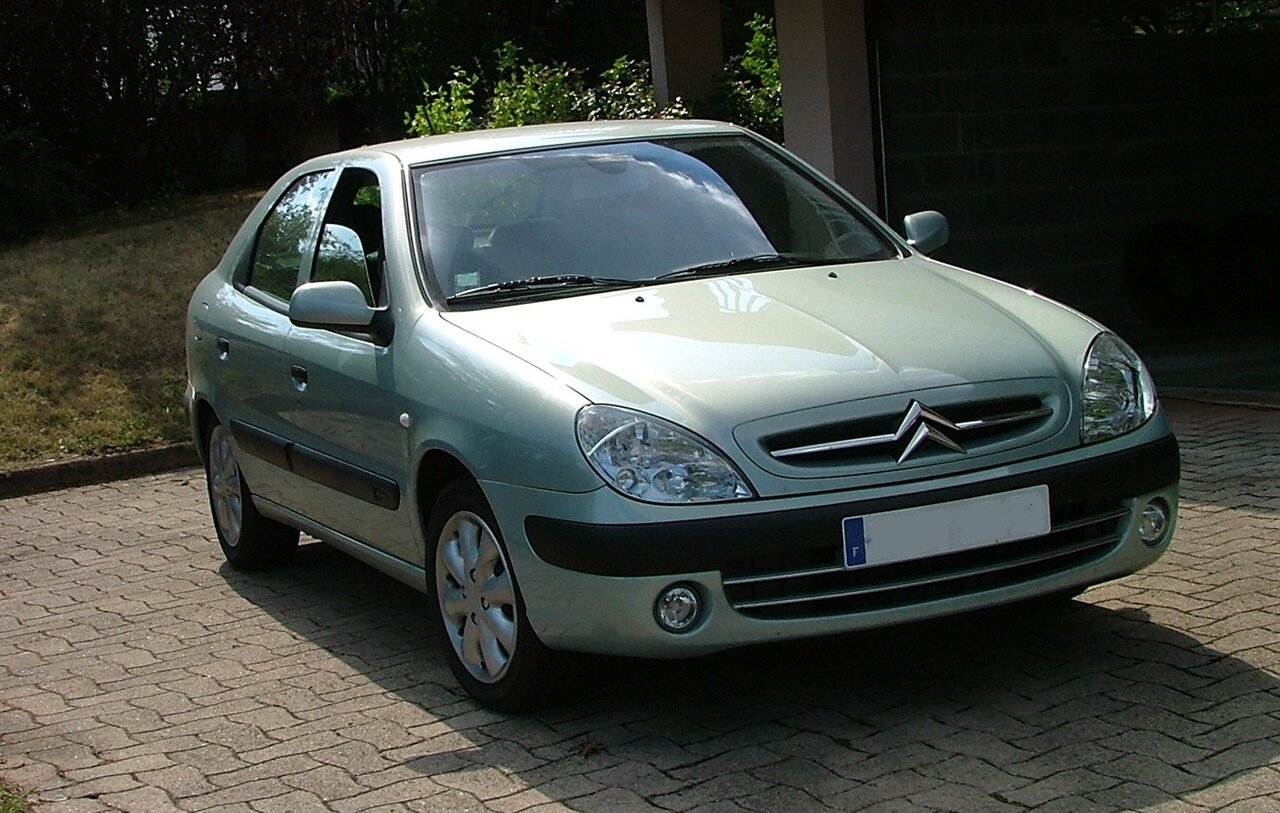 Πράσινο Citroën Xsara Picasso παρκαρισμένο σε πλακόστρωτο δρόμο.