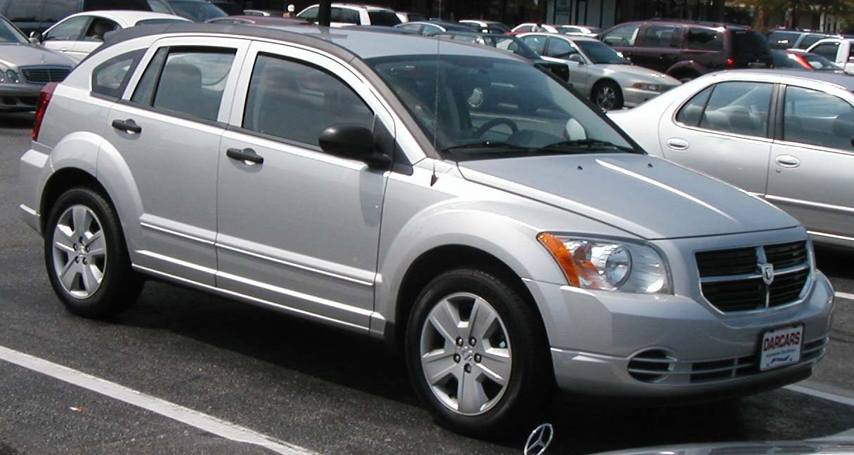 Ασημί Dodge Caliber σταθμευμένο σε εξωτερικό χώρο στάθμευσης.