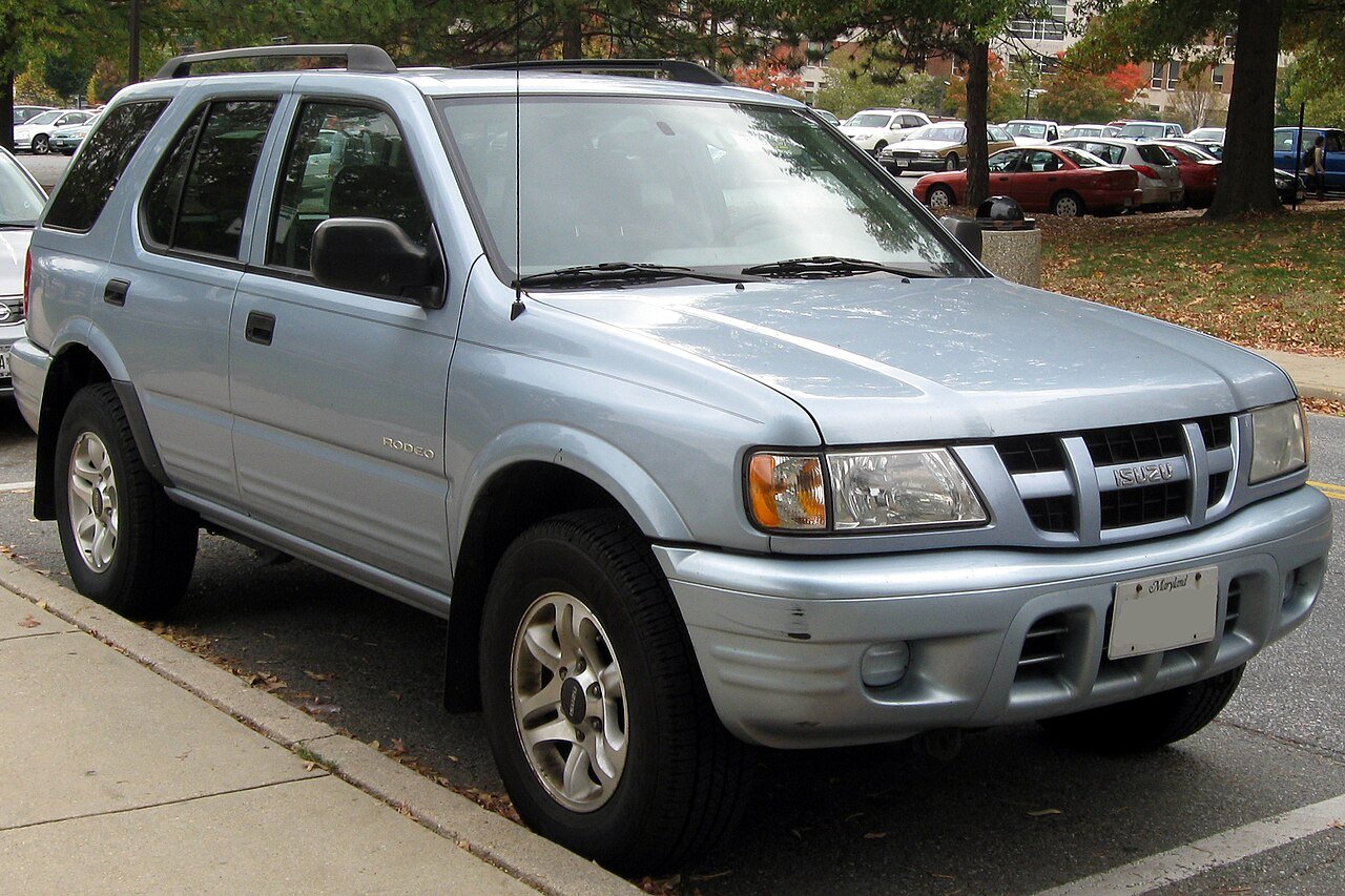 Ένα ασημί Isuzu Rodeo παρκαρισμένο στο δρόμο.