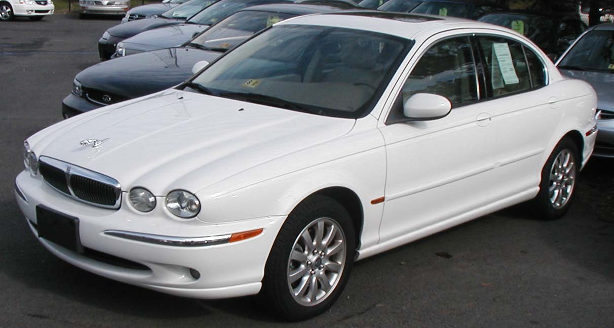Λευκή Jaguar X-Type, μοντέλο σεντάν, παρκαρισμένη σε εξωτερικό χώρο.