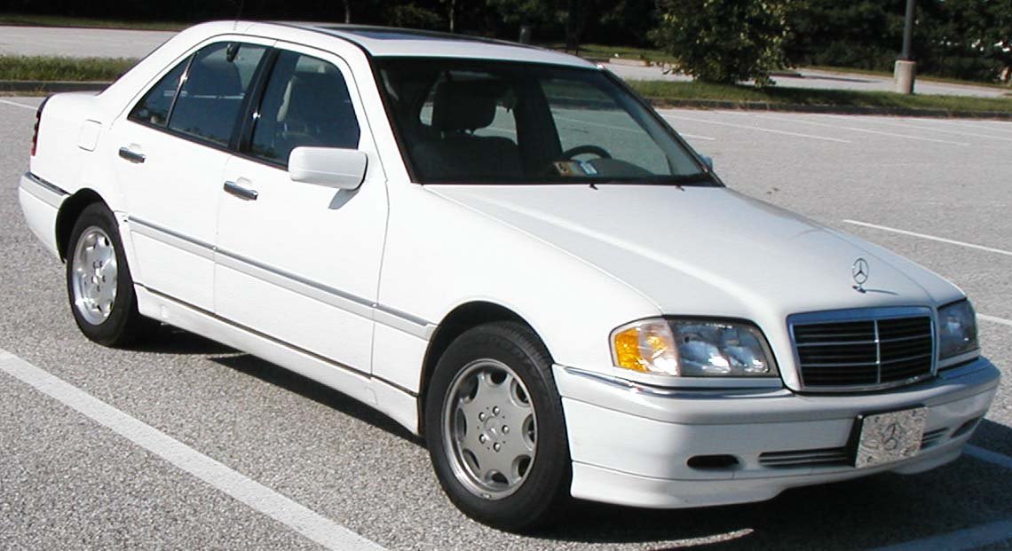 Λευκή Mercedes-Benz C-Class σταθμευμένη σε εξωτερικό χώρο.