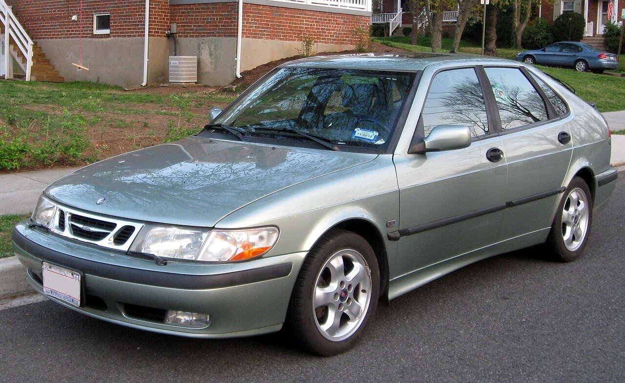 Πράσινο Saab 9-3 hatchback παρκαρισμένο σε δρόμο, με σπίτια στο βάθος.