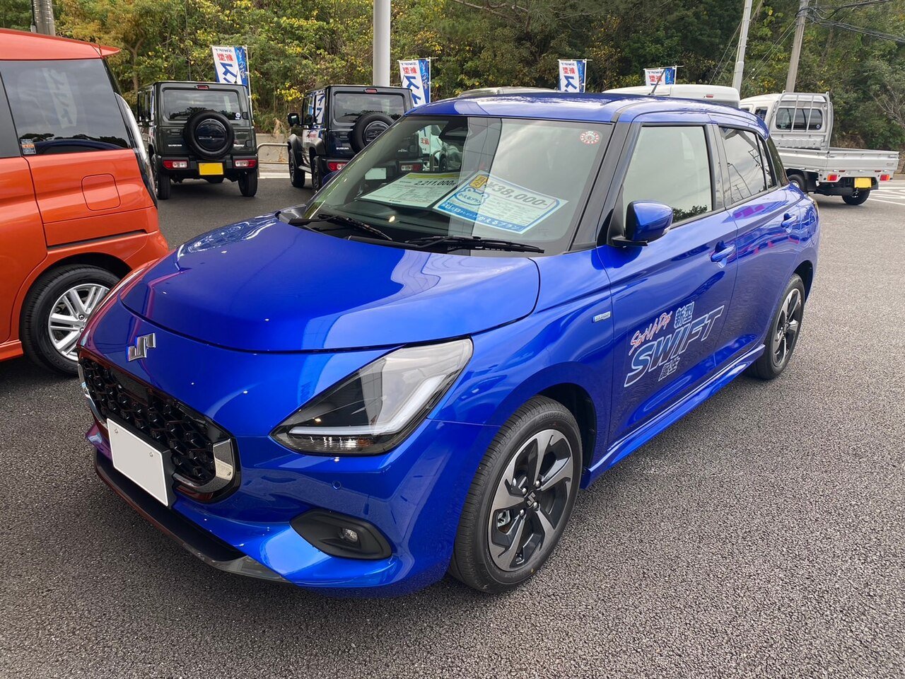 Μπλε Suzuki Swift, πλήρης εξωτερική όψη, σταθμευμένο σε εξωτερικό χώρο.